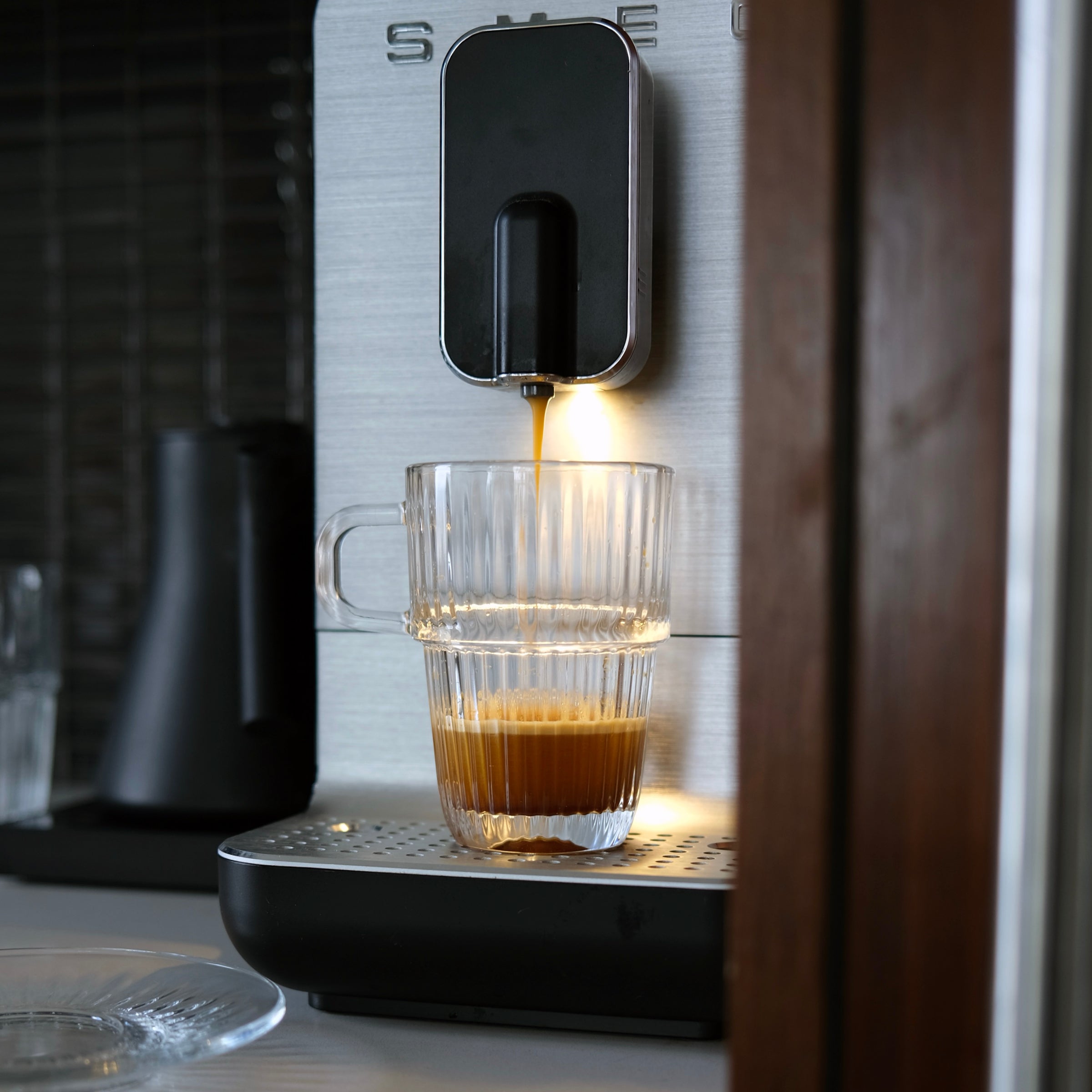 Espresso being dispensed into a glass from a coffee machine.