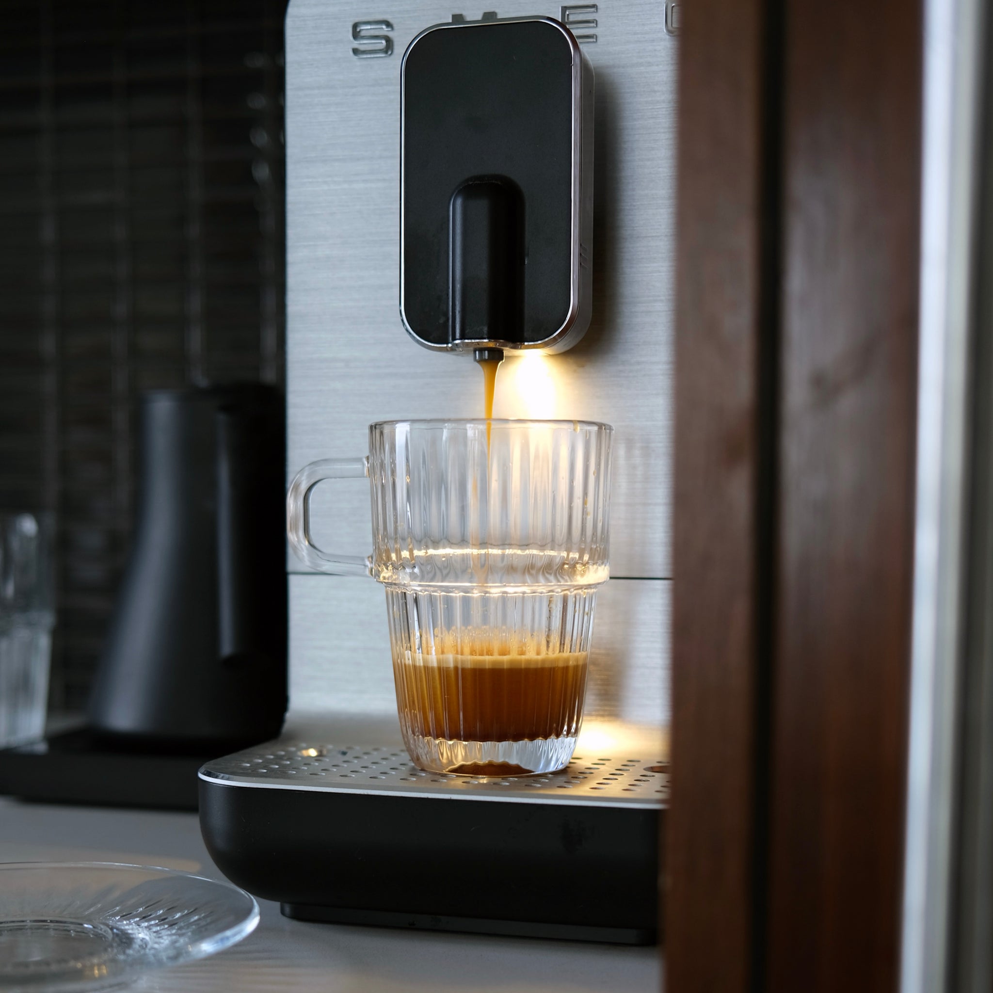 Espresso being dispensed into a glass from a coffee machine.