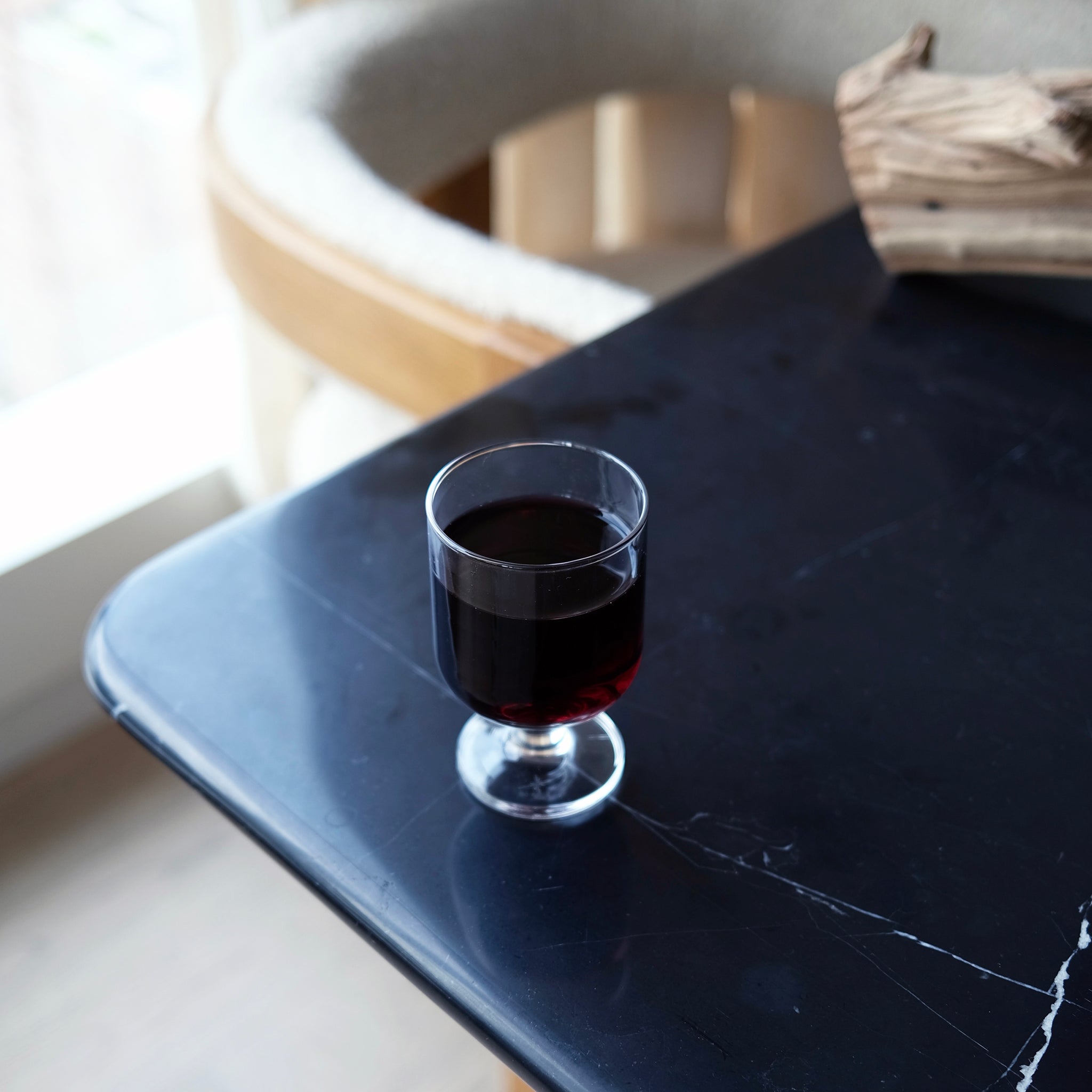 Glass with red wine on a black tray with a blurred background