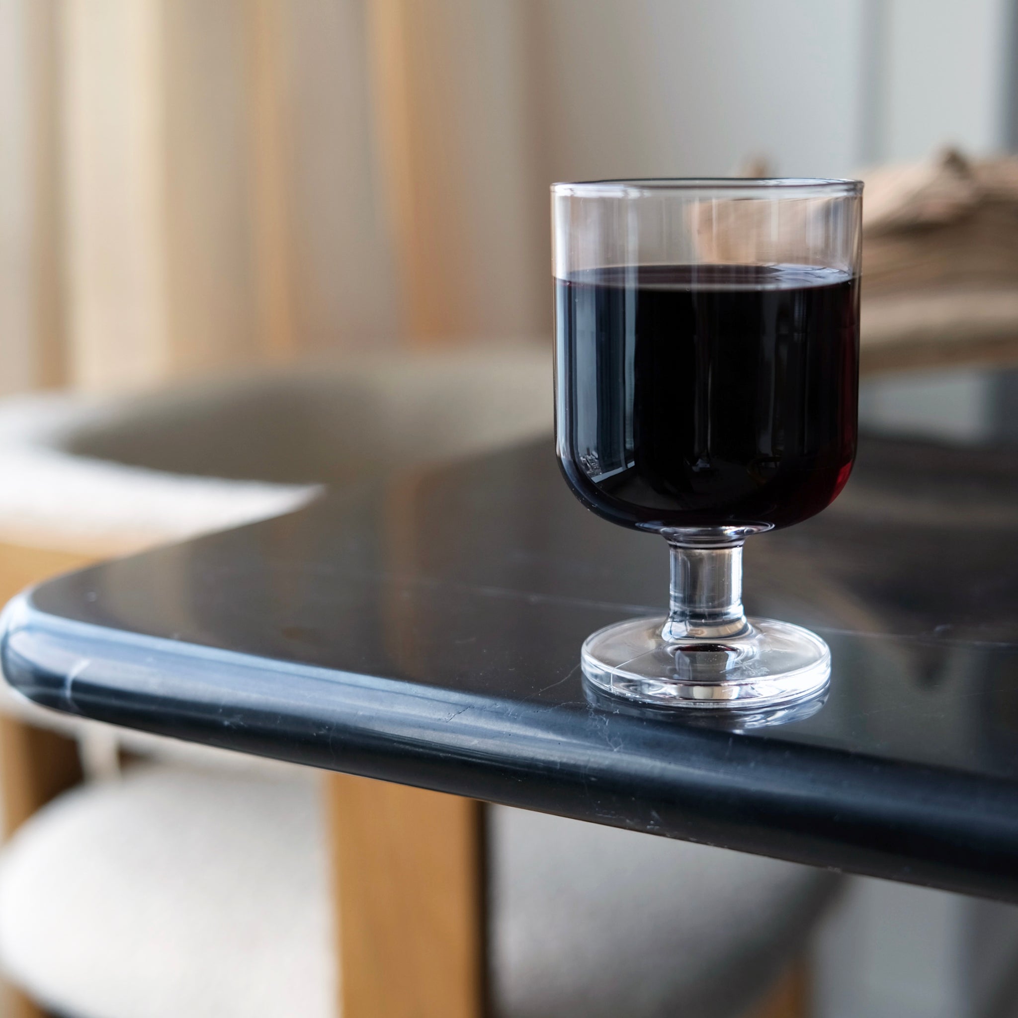 Glass with red wine on a black marble surface with a blurred background