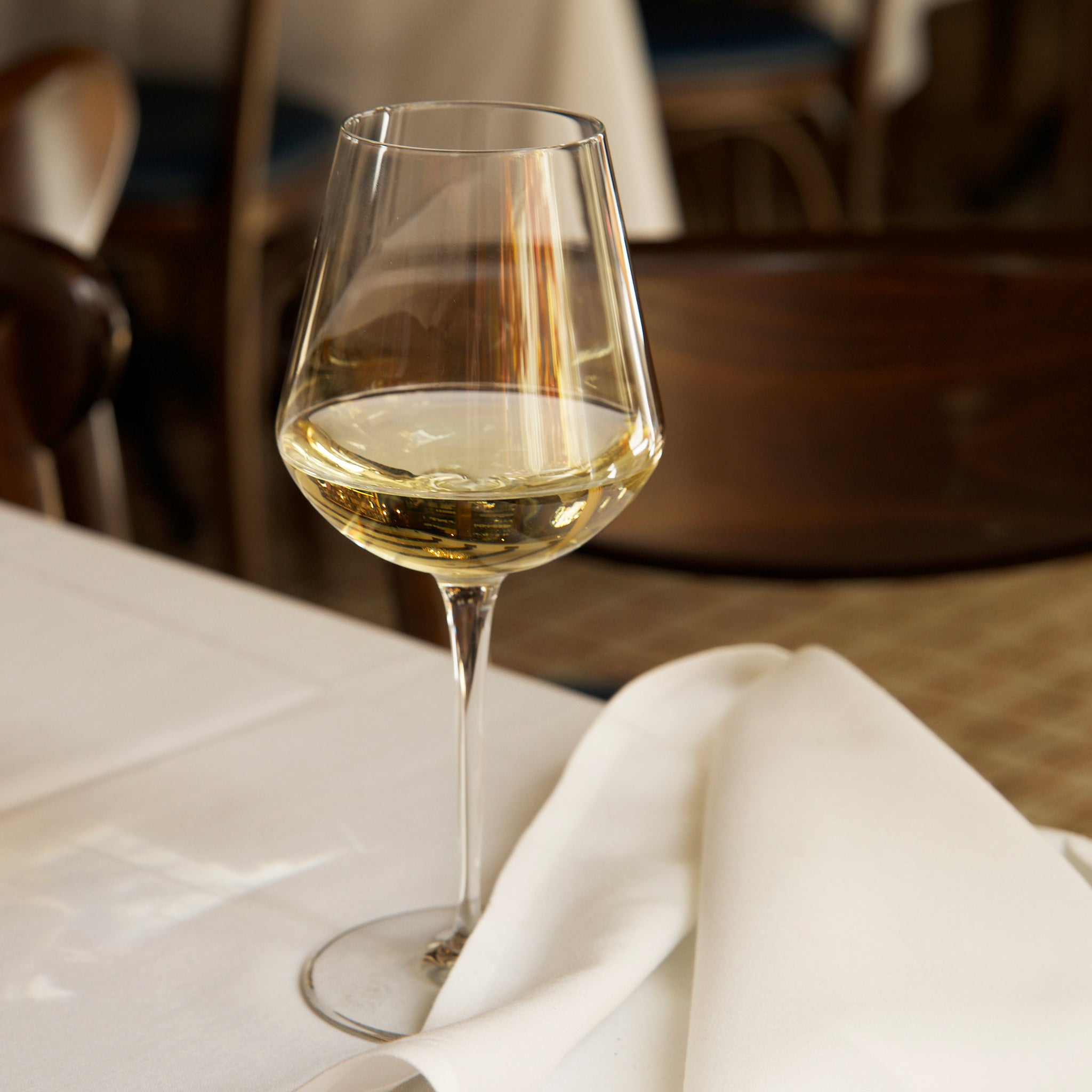 Glass of white wine on a table with a blurred background