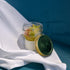 Jar of dessert with a green lid on a white surface with a blue background